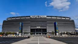 New York / NJ — MetLife Stadium: large open-air stadium with a curved facade under a blue sky.