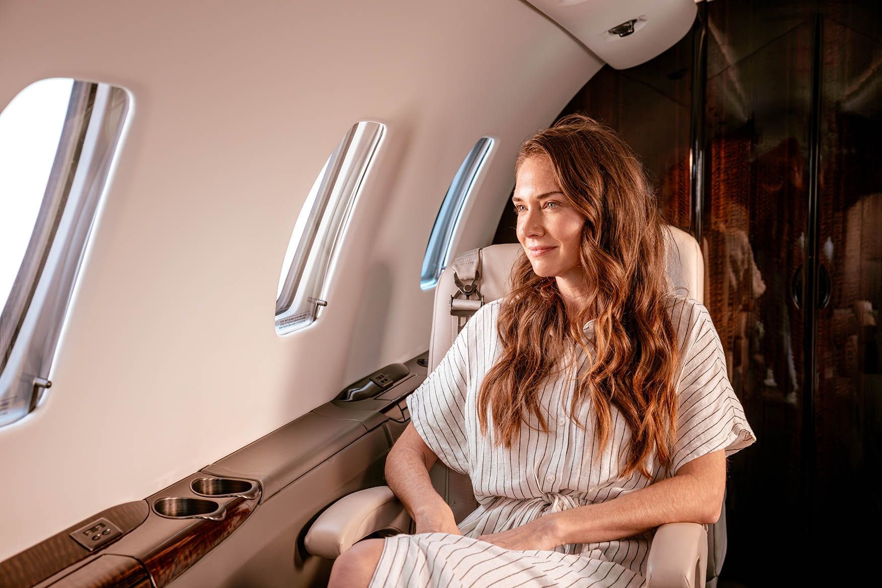 Woman sitting on a private jet looking at the window