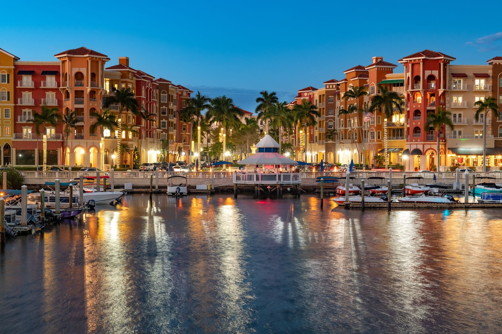 Aerial view of Naples, Florida waterfront showcasing upscale coastal architecture and private boat docks in the evening
