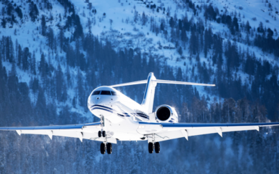 Private jet flying beside snowy mountain